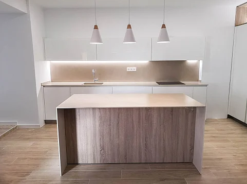 Cocina blanca y madera abierta al salón con isla